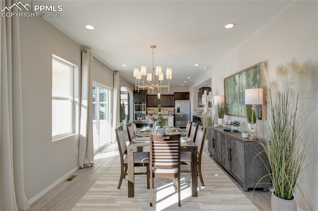 Image 5 of 32: Dining area featuring a chandelier, light wood-type flooring, and recessed 
