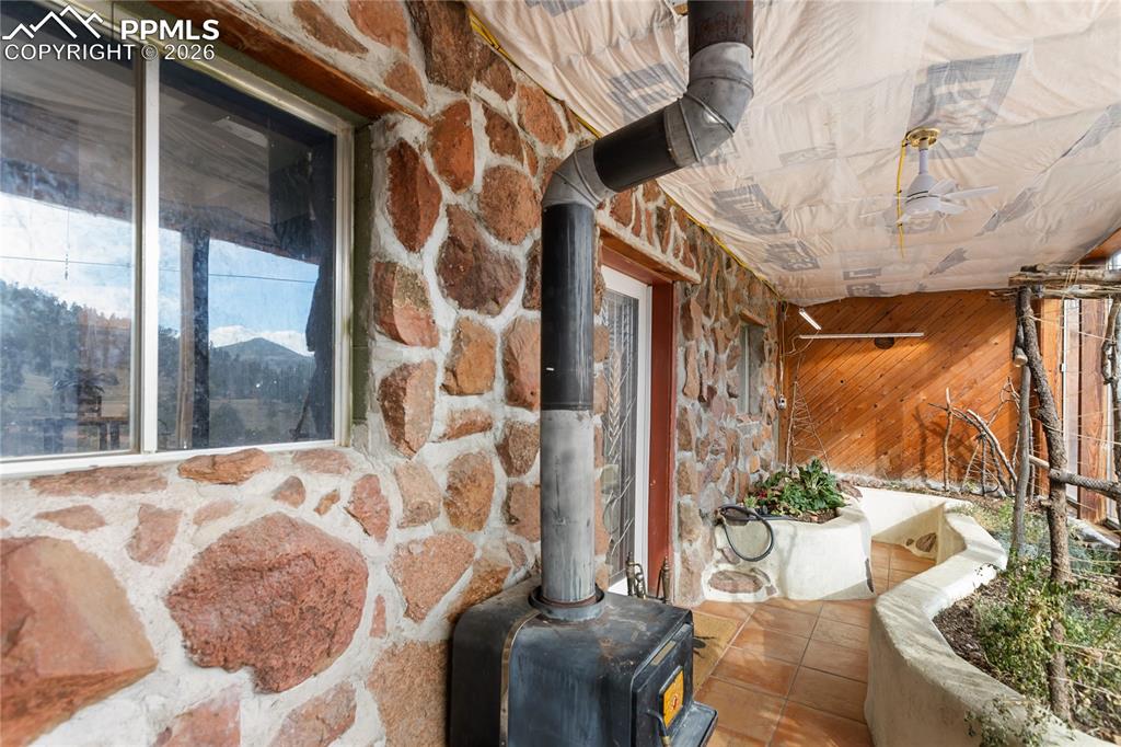 Image 28 of 46: Garden sunroom and wood burning fireplace