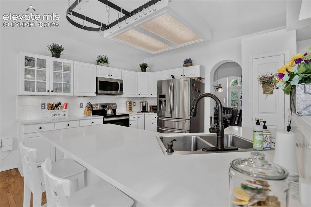 Image 16 of 49: Modern kitchen featuring a large island with dual stainless steel sinks and