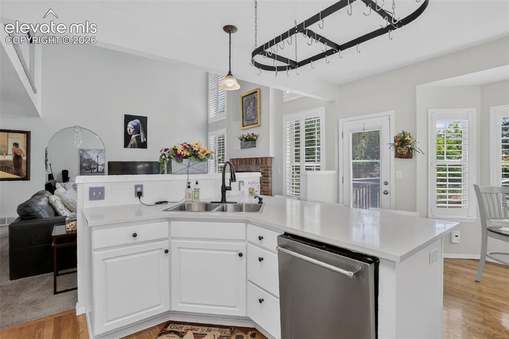 Image 18 of 49: Modern kitchen featuring white cabinetry, light countertops, a stainless st