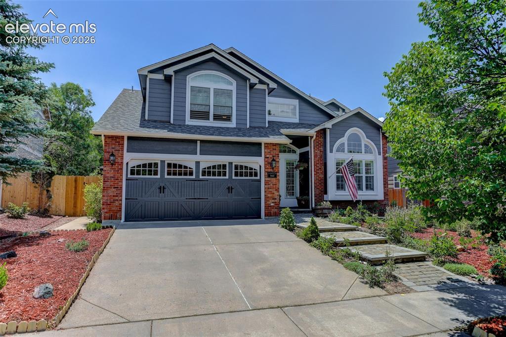 Image 3 of 49: Two-story residence featuring a gray exterior with brick accents, an attach