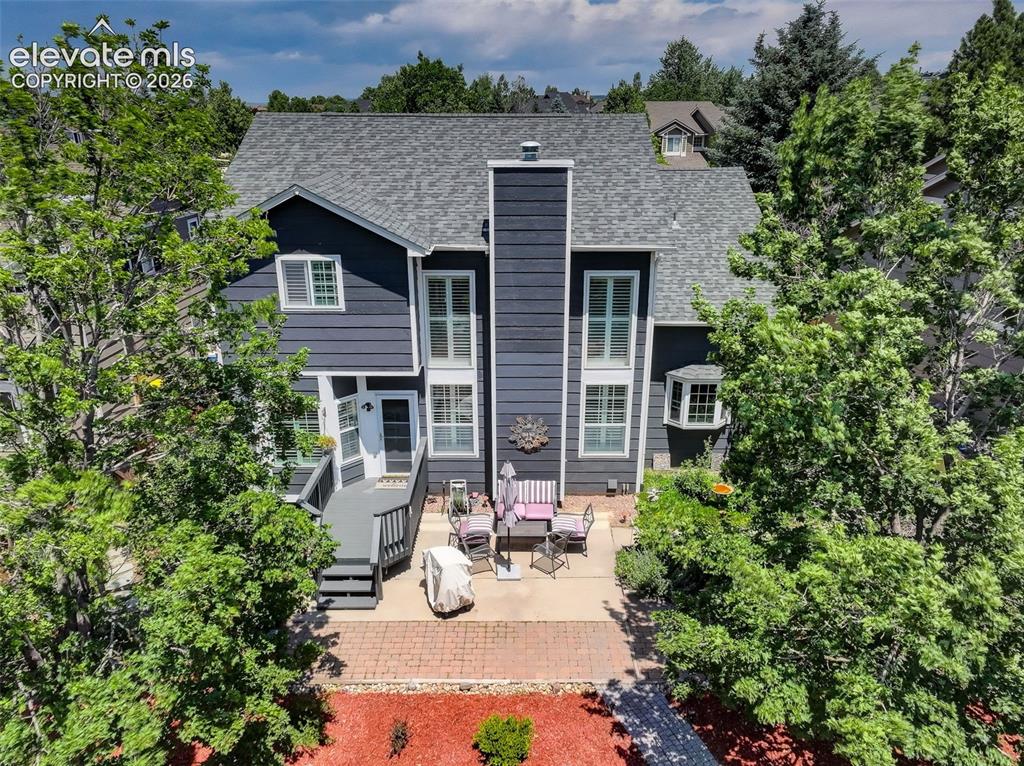 Image 33 of 47: Rear exterior featuring a multi-level deck with stairs, a stone paver patio