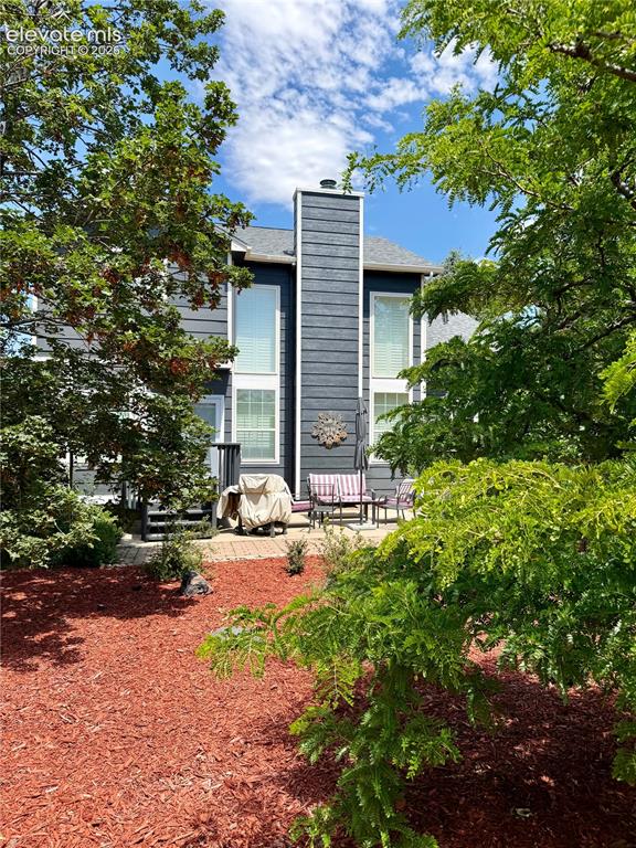 Image 34 of 49: Rear exterior with a multi-level deck and brick paver patio