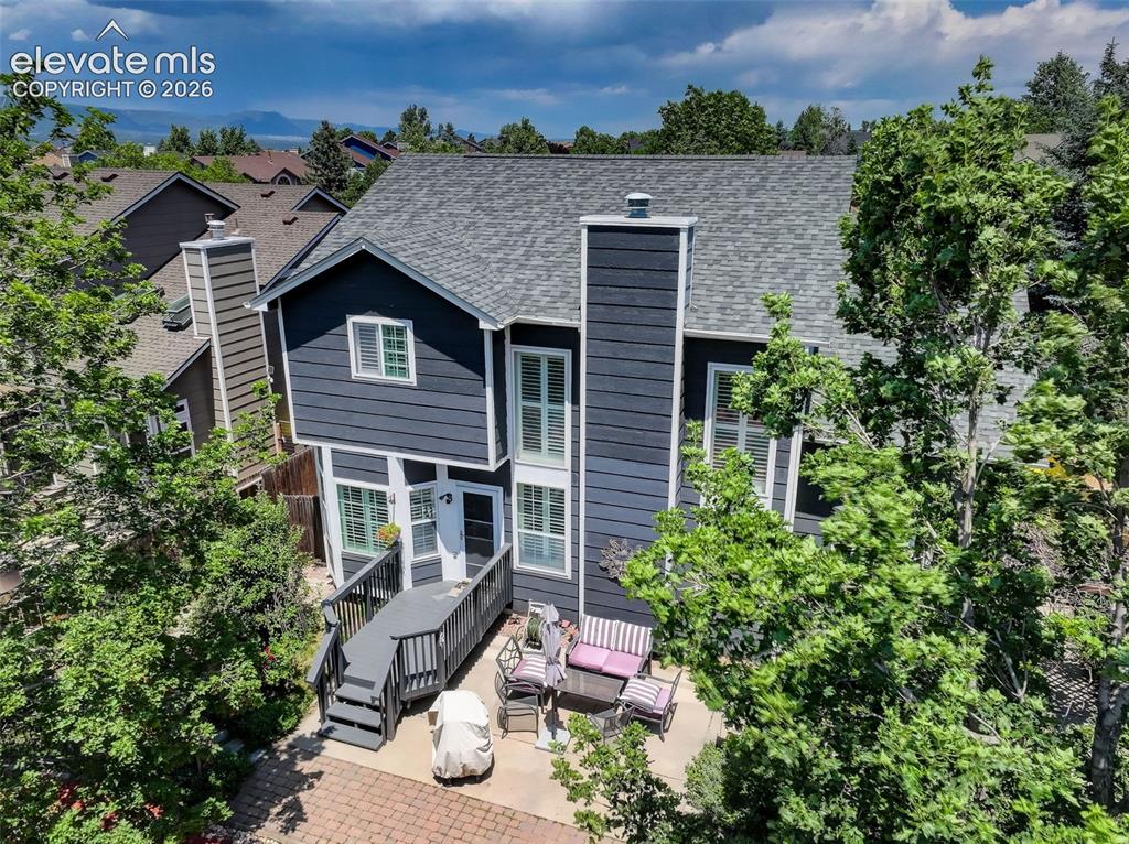 Image 46 of 47: Two-story residence featuring dark blue siding, a multi-pane glass entry do