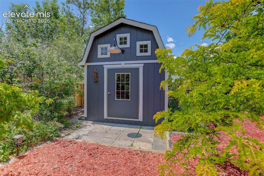 Image 47 of 49: Aerial property showcasing a dark-hued exterior with a grey shingle roof, s