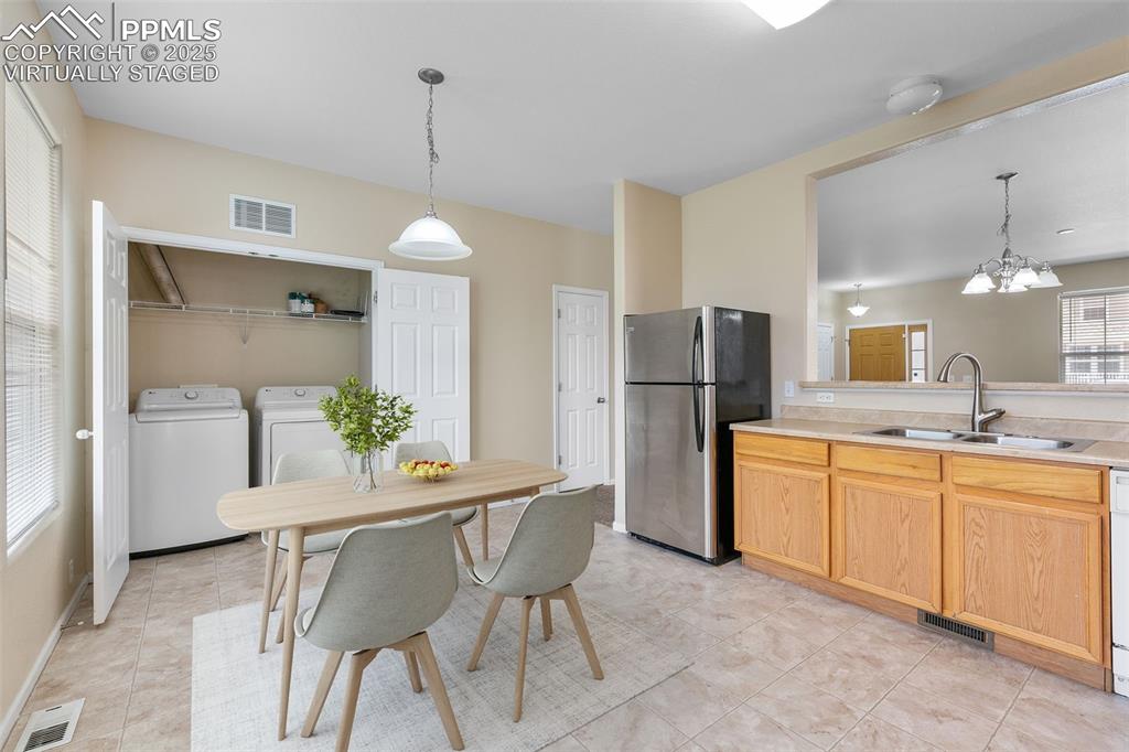 Image 16 of 38: *Virtually Staged* Kitchen featuring washing machine and clothes dryer, fre