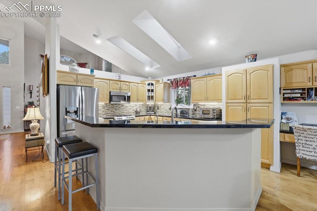 Image 12 of 49: Huge kitchen with expansive granite countertops, high-end appliances.