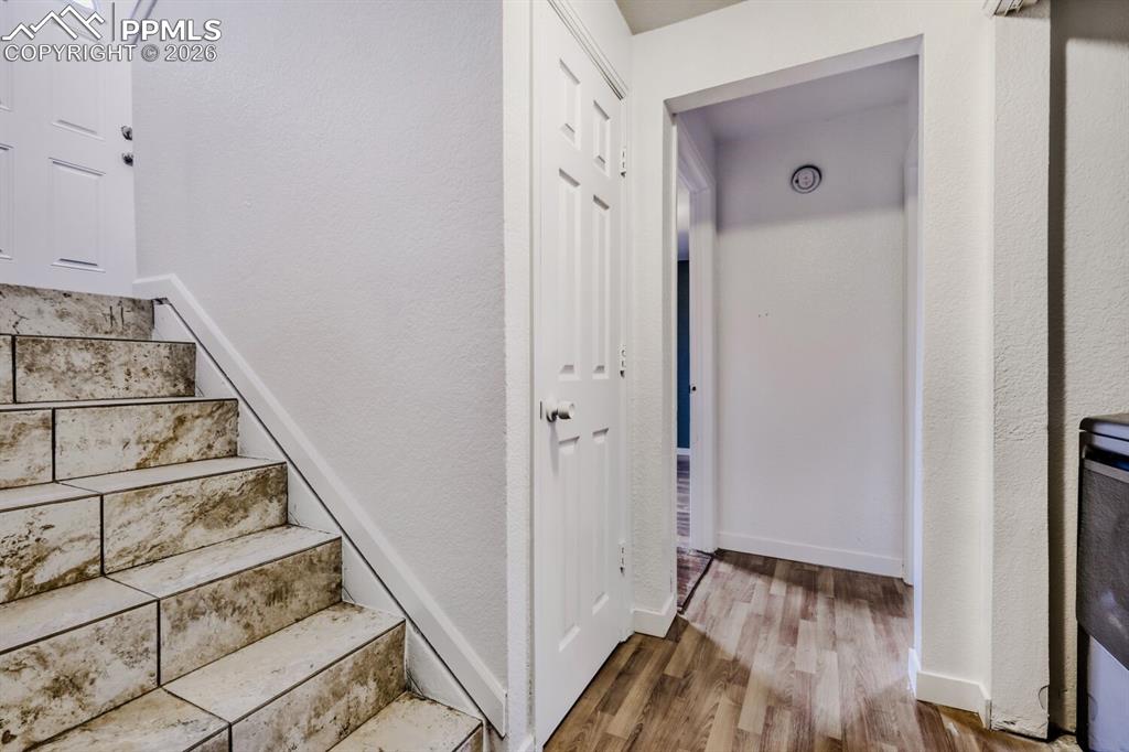 Image 15 of 36: Stairs with a textured wall and wood finished floors