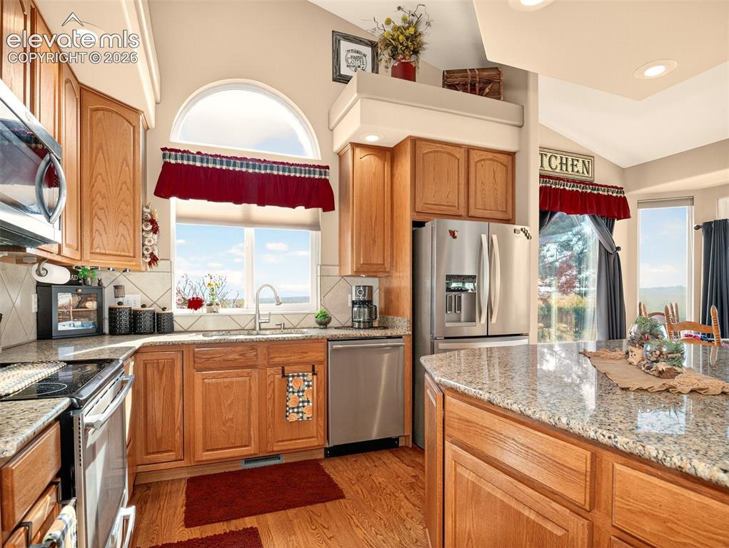 Image 11 of 49: Kitchen with ample cabinets, granite counters, large island and stainless-s