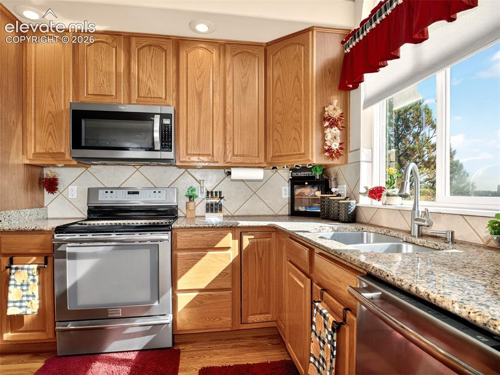 Image 12 of 49: Kitchen with ample cabinets, granite counters, large island and stainless-s