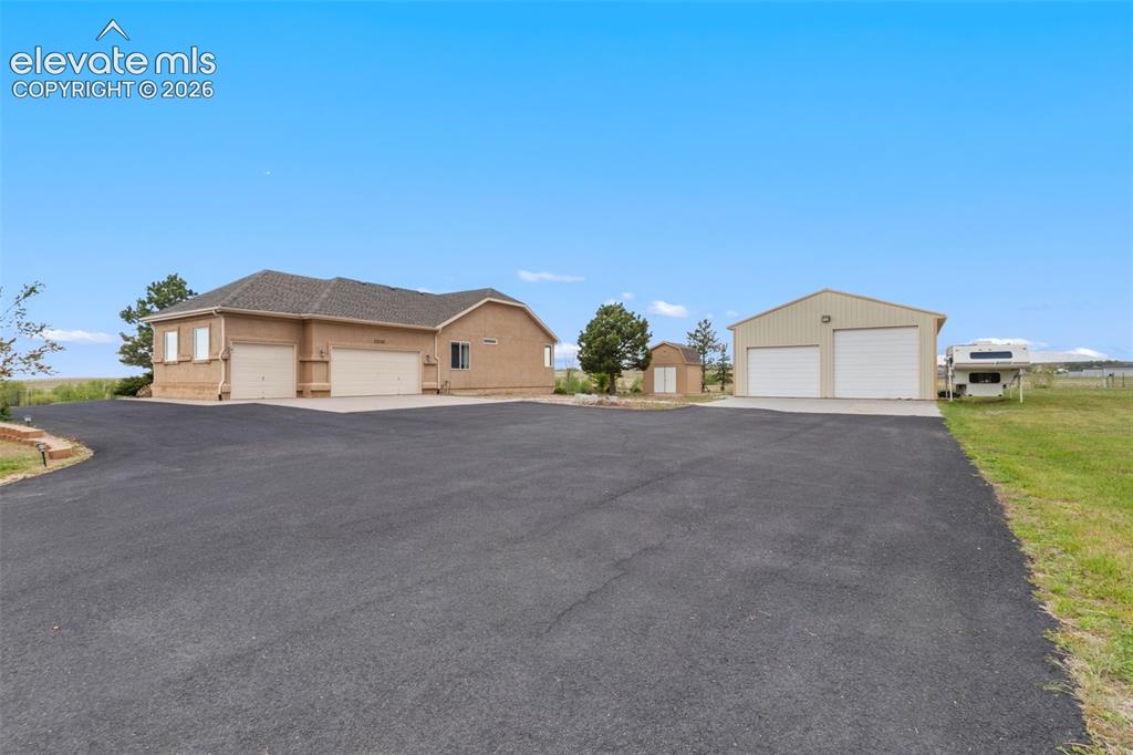 Image 3 of 49: Beautiful stucco home with attached 3-car garage, large shop, storage shed,