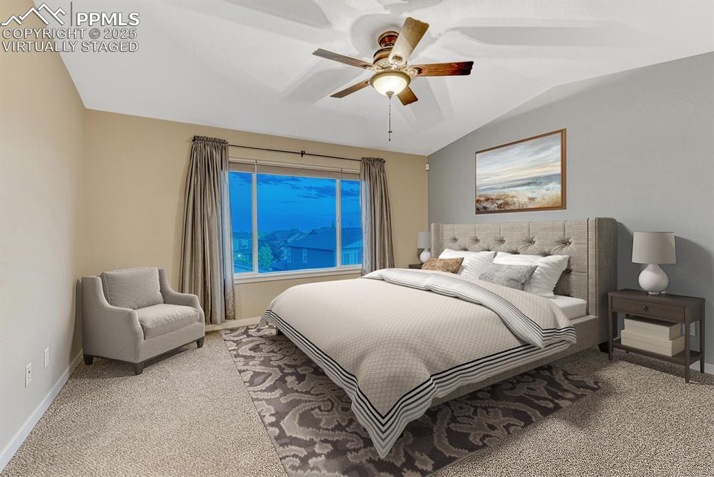 Image 15 of 50: Primary bedroom has vaulted ceilings. Virtually staged.