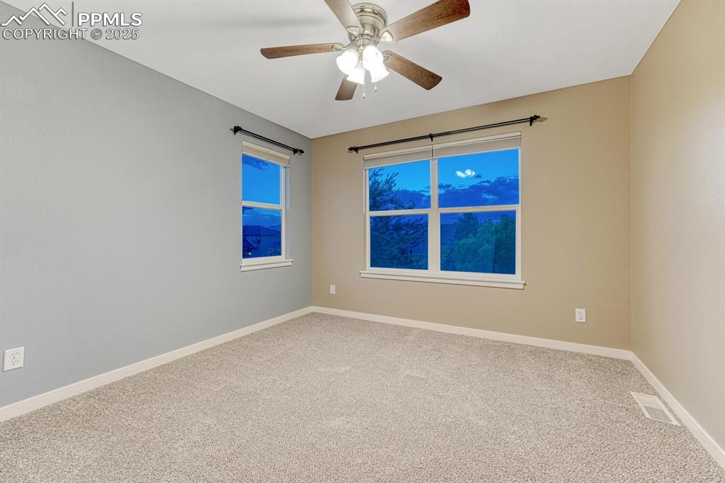 Image 25 of 50: Carpeted empty room with a ceiling fan and baseboards