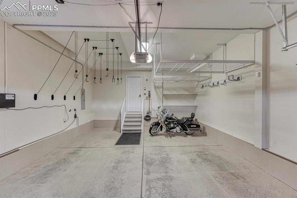 Image 30 of 50: Insulated 24ft deep garage optimized for storage, includes charging station