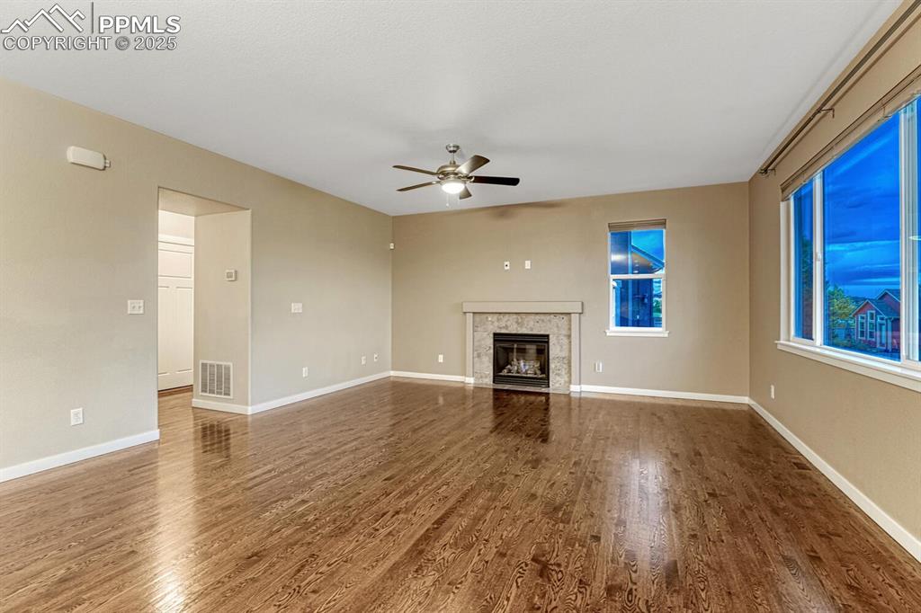 Image 42 of 50: Unfurnished living room featuring ceiling fan, wood finished floors, and a 