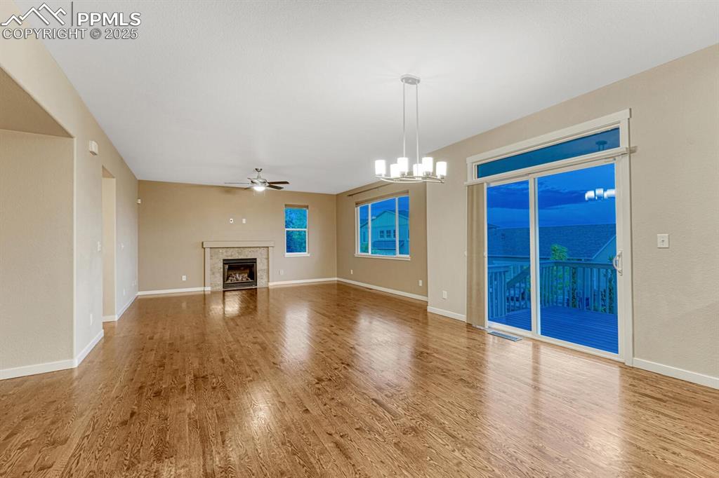 Image 43 of 50: Unfurnished living room with ceiling fan, wood finished floors, a tiled fir