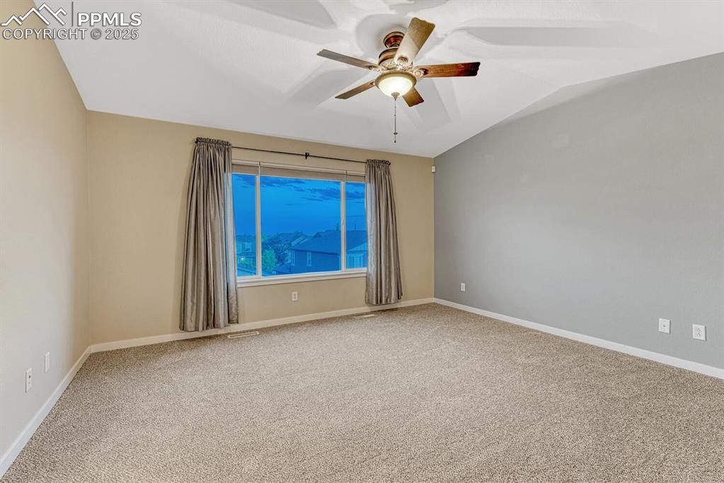 Image 45 of 50: Unfurnished room featuring ceiling fan, carpet flooring, and vaulted ceilin