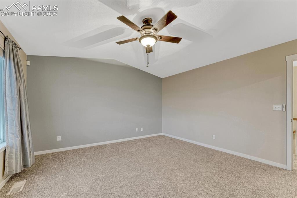 Image 46 of 50: Carpeted spare room featuring a ceiling fan and lofted ceiling