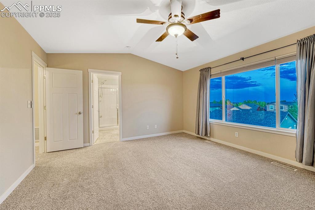 Image 47 of 50: Unfurnished room with carpet, a ceiling fan, and lofted ceiling