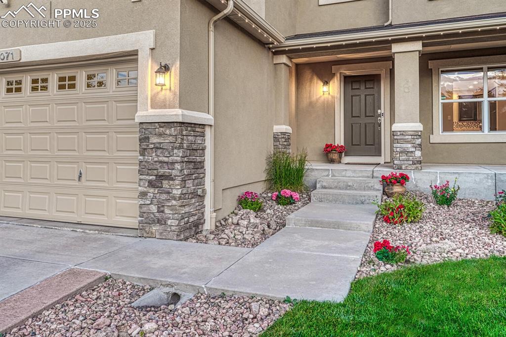 Image 5 of 50: View of exterior entry with stucco siding and stone siding