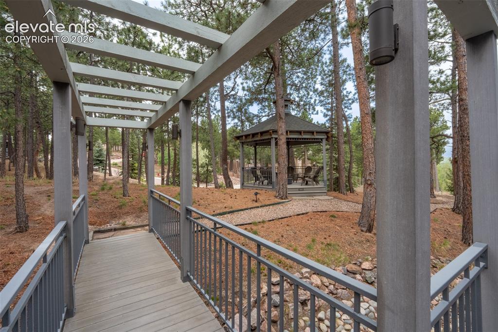 Image 42 of 49: Back yard bridge to pergola sitting area