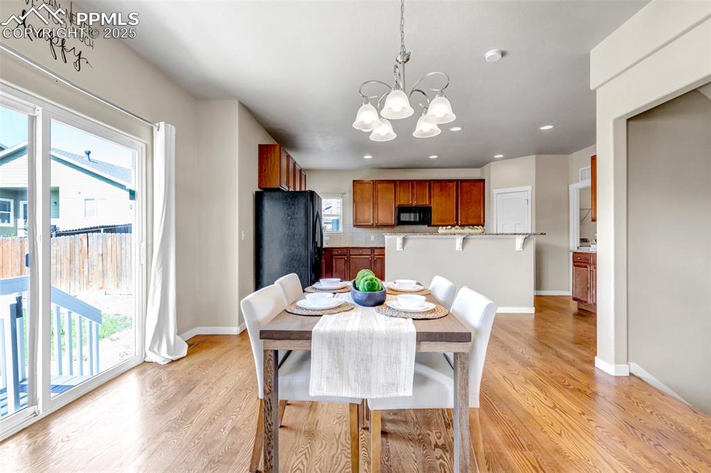 Image 10 of 37: Dining room with light wood-style flooring, a chandelier, and recessed ligh