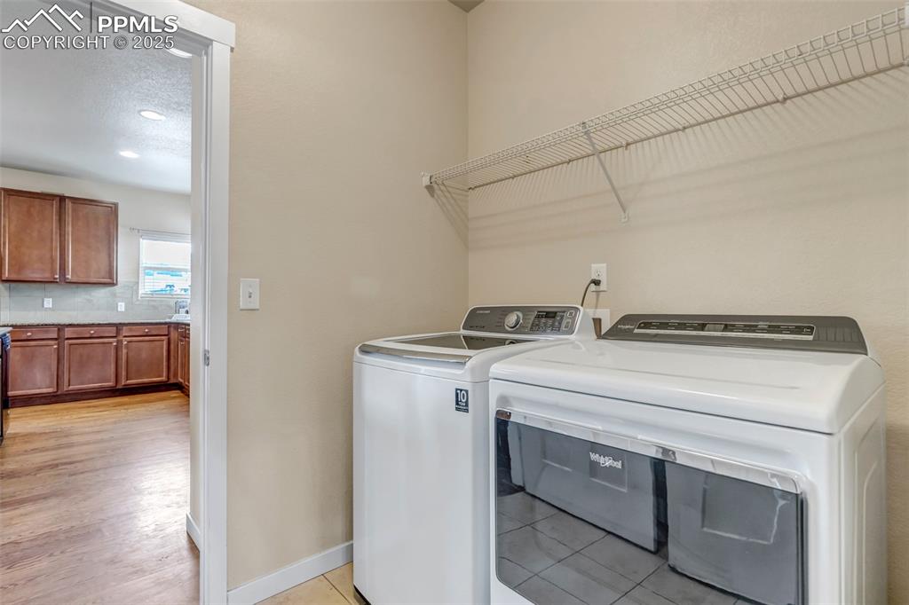 Image 16 of 37: Laundry room featuring washer and dryer, a textured ceiling, and light tile