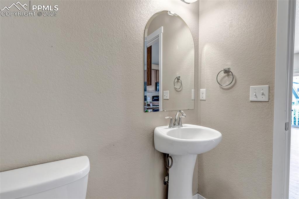 Image 17 of 37: Half bath with a textured wall and toilet