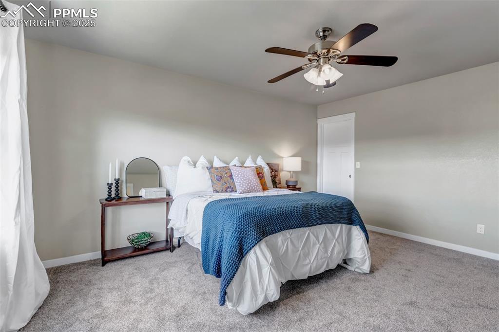 Image 19 of 37: Carpeted bedroom with baseboards and ceiling fan
