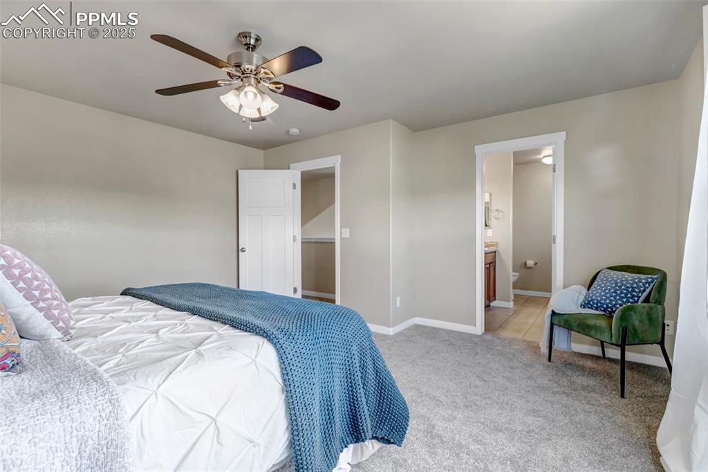 Image 20 of 37: Bedroom with carpet floors, ceiling fan, and connected bathroom