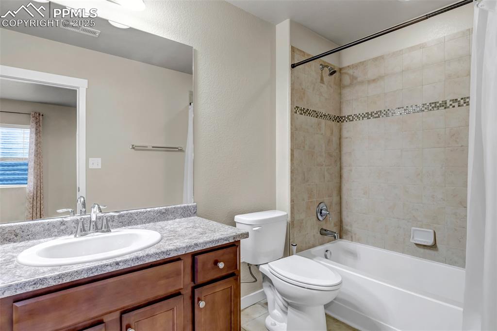 Image 32 of 37: Bathroom featuring shower / bath combo with shower curtain, a textured wall