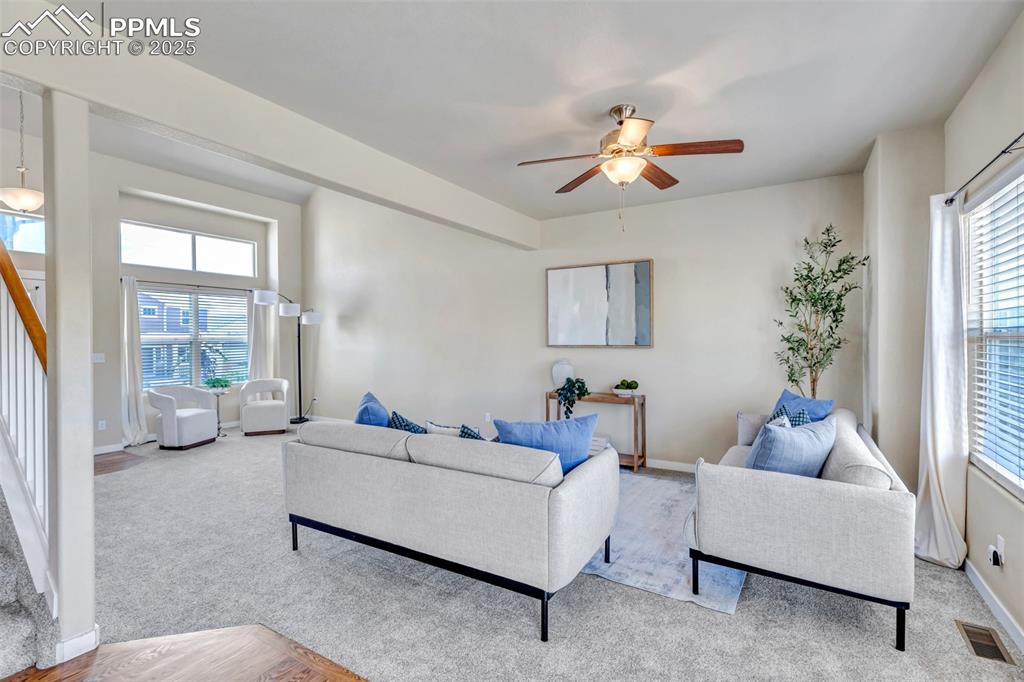 Image 8 of 37: Living room with stairs, a ceiling fan, and carpet