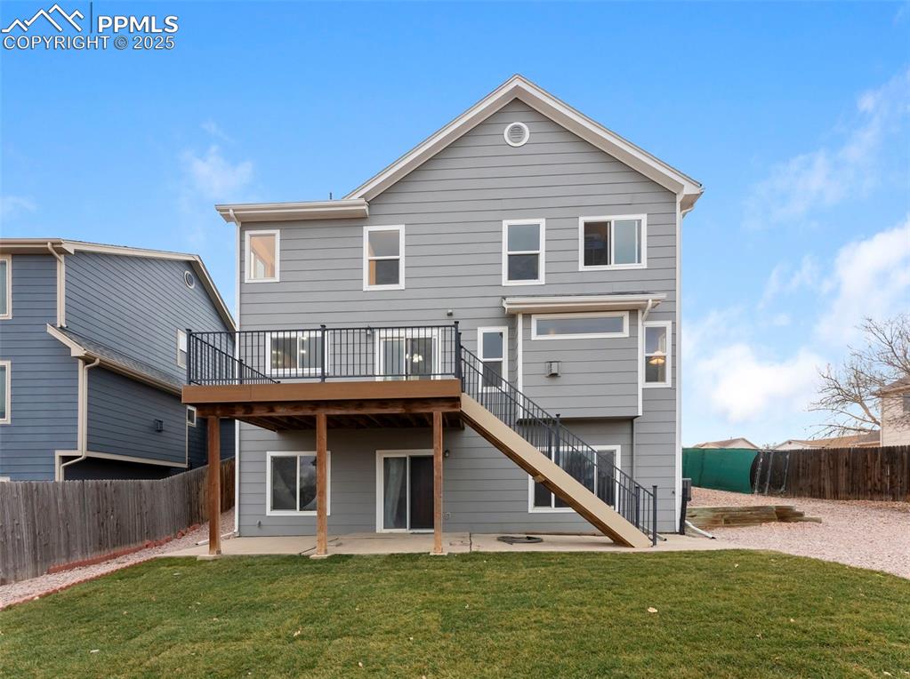 Image 24 of 28: Back exterior showing walk-out basement and deck