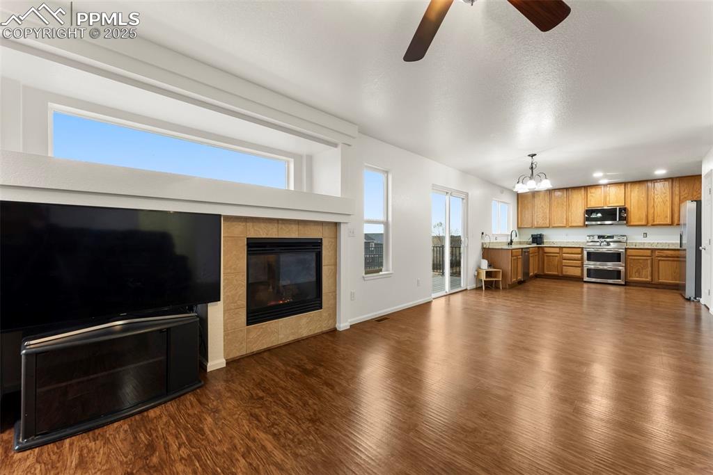 Image 9 of 28: Open living room with gas fireplace and great natural light