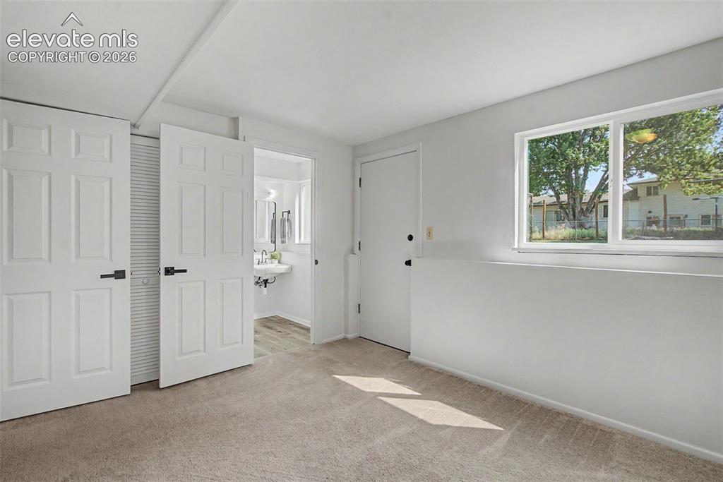Image 32 of 37: lower bedroom, attached 1/2 bath, walk-out to backyard