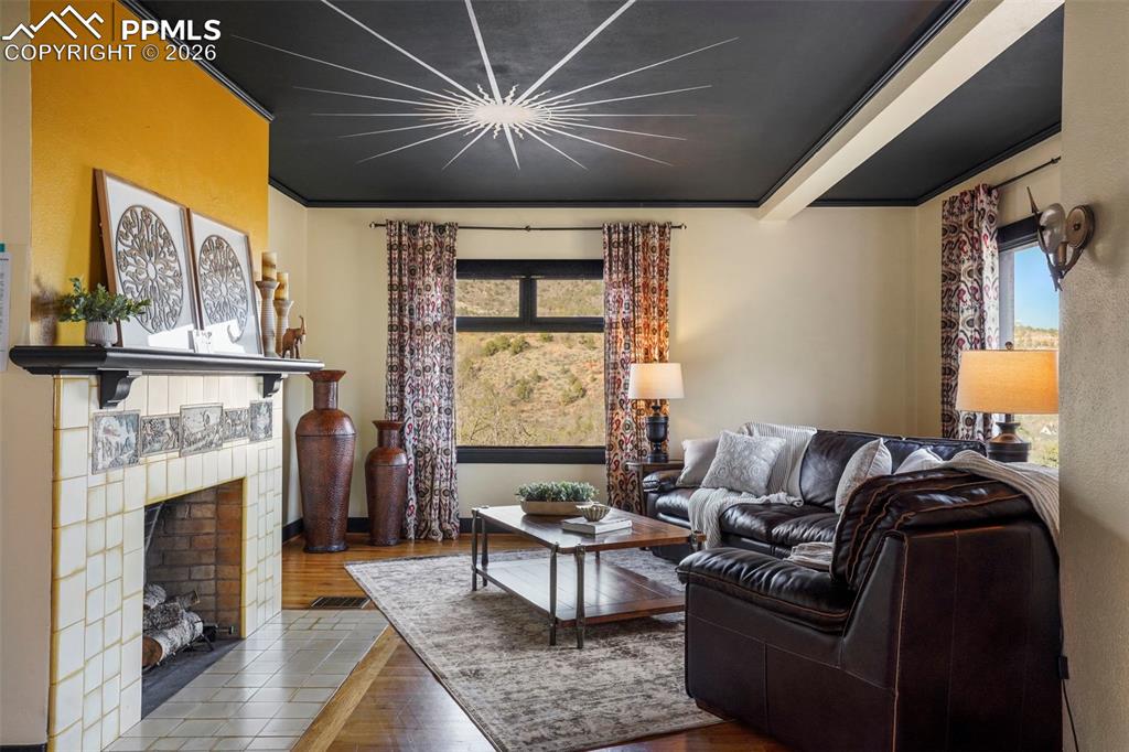 Image 16 of 47: Living room with wood finished floors and a fireplace