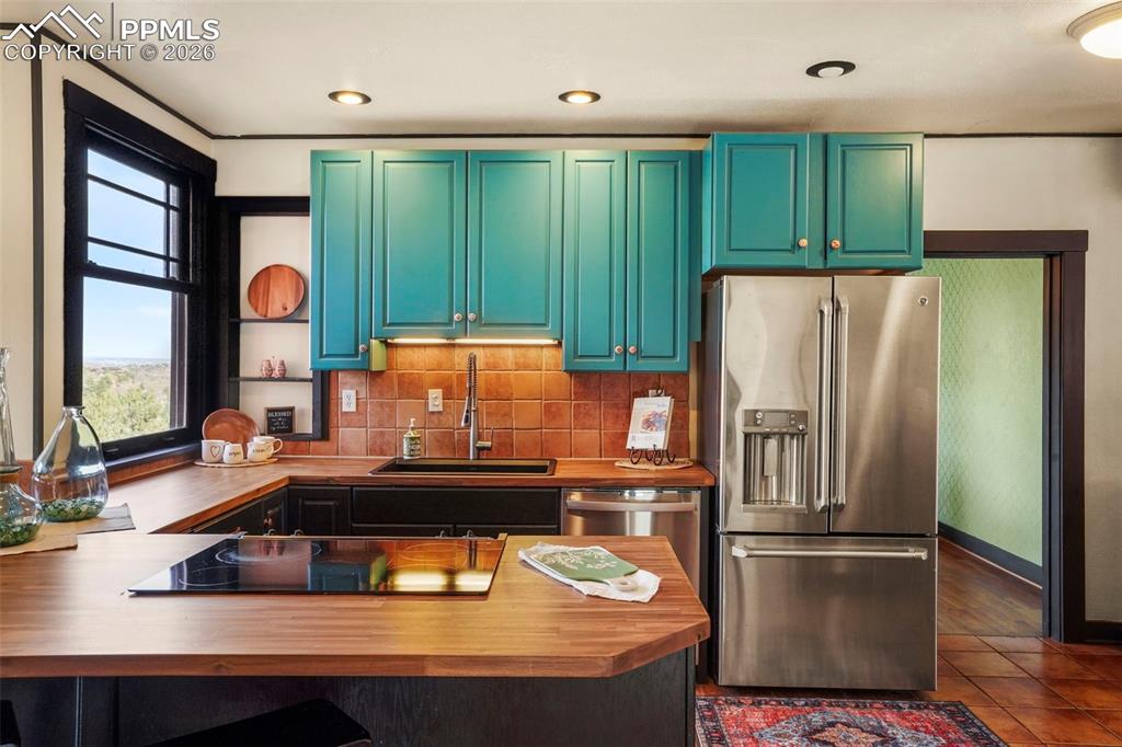 Image 26 of 47: Kitchen view with tile floors, stainless steel appliances, wooden counters,