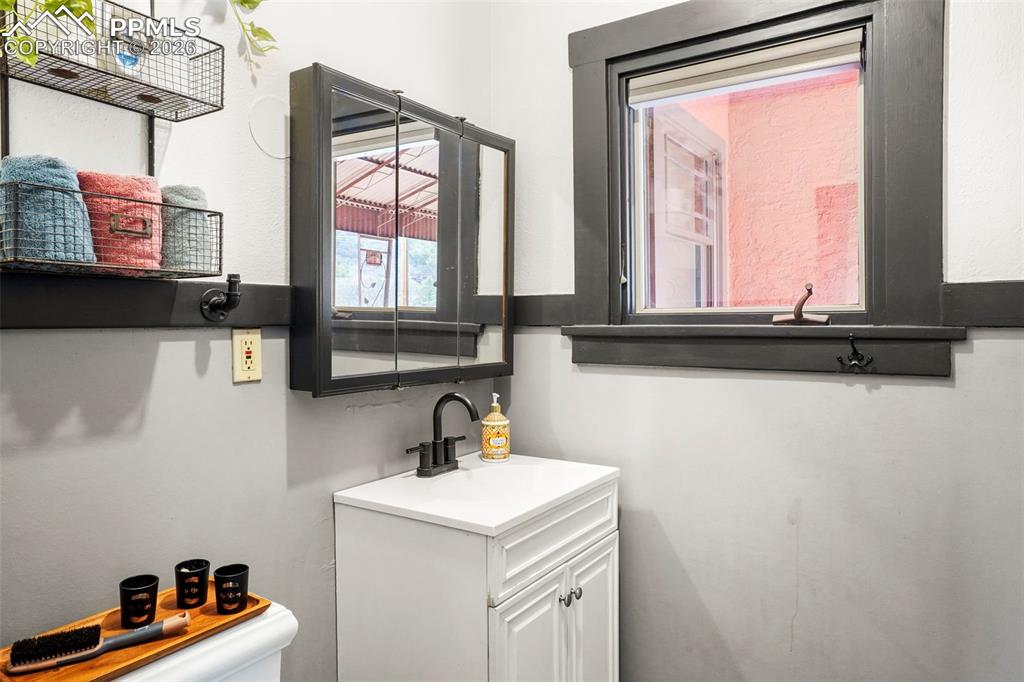 Image 34 of 47: Main level 3/4 bath toilet and vanity