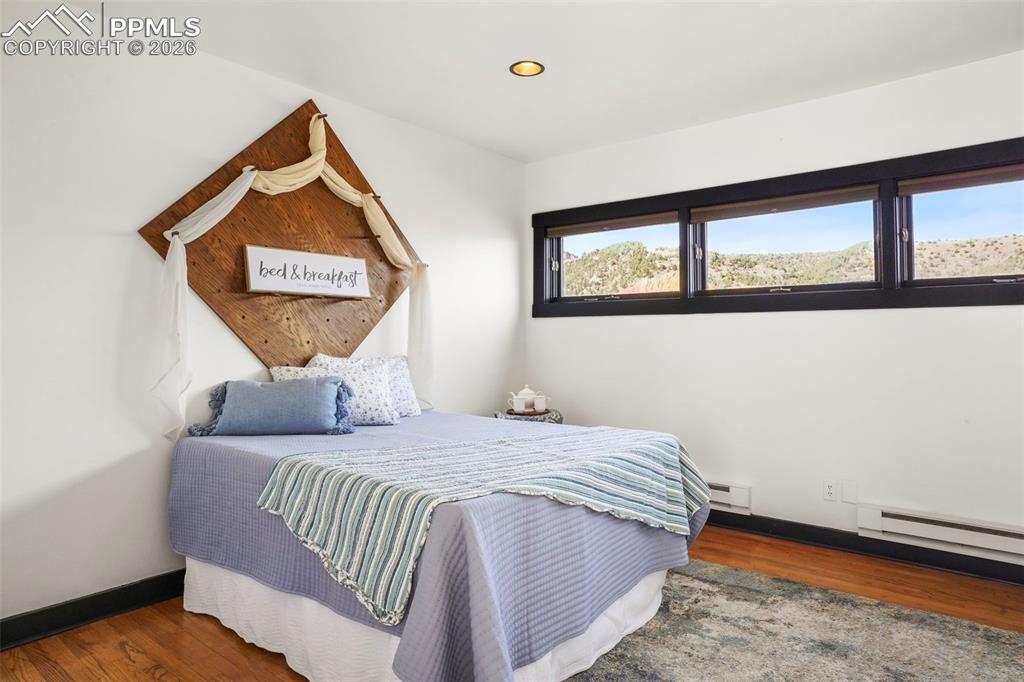 Image 36 of 47: Primary main level bedroom with walk in closet, baseboards, recessed lighti