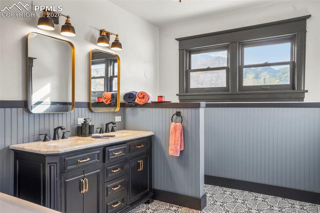 Image 40 of 47: Upper level full bathroom featuring double vanity and double sinks, a wains