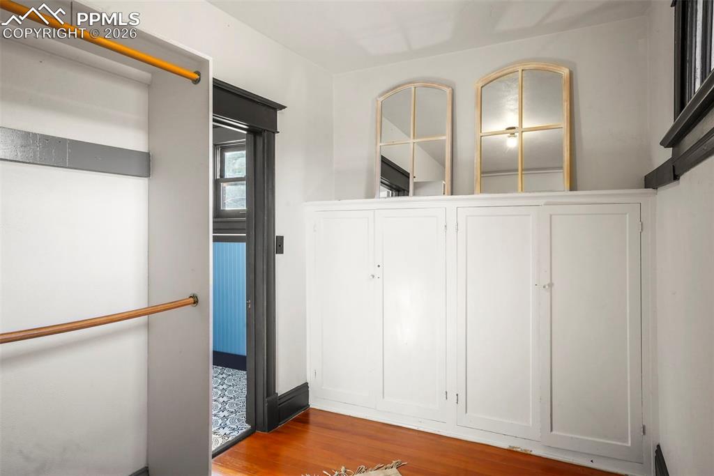 Image 44 of 47: Primary upstairs bedroom walk in closet featuring wood finished floors