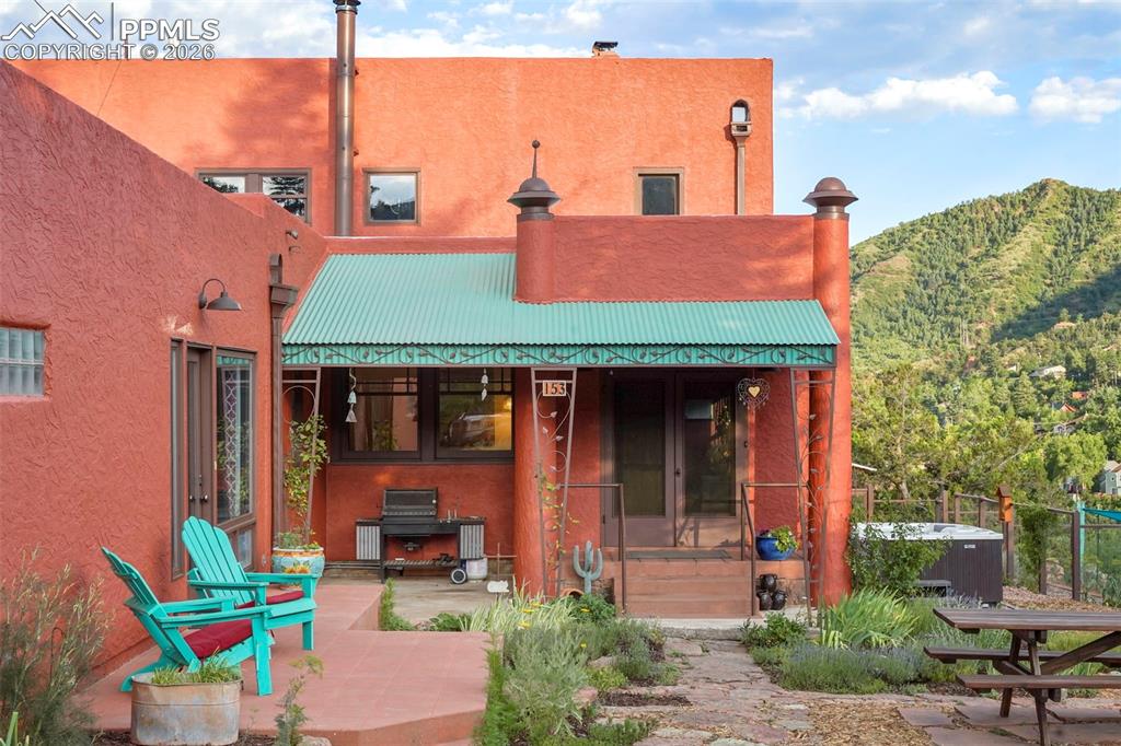 Image 5 of 47: Rear view of house with a mountain view, a patio area, stucco siding, and m