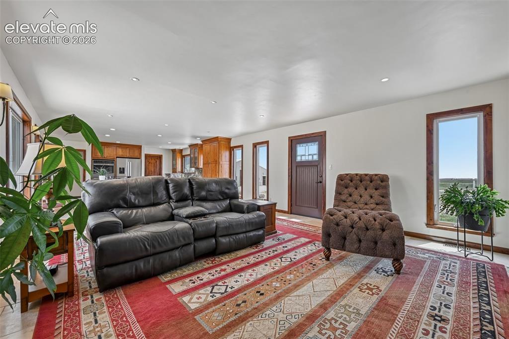 Image 3 of 36: Open-concept living area featuring recessed lighting, tile flooring, and wo