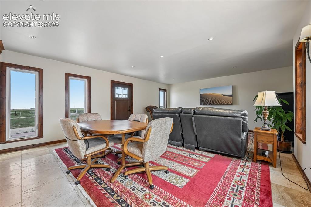 Image 4 of 36: Open area encompasses tv area, dining area, kitchen, and access to laundry