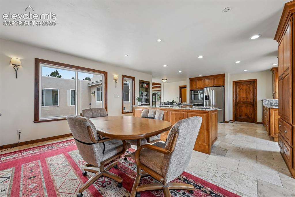 Image 8 of 36: Open-concept kitchen featuring wood-finish cabinetry, stainless steel appli