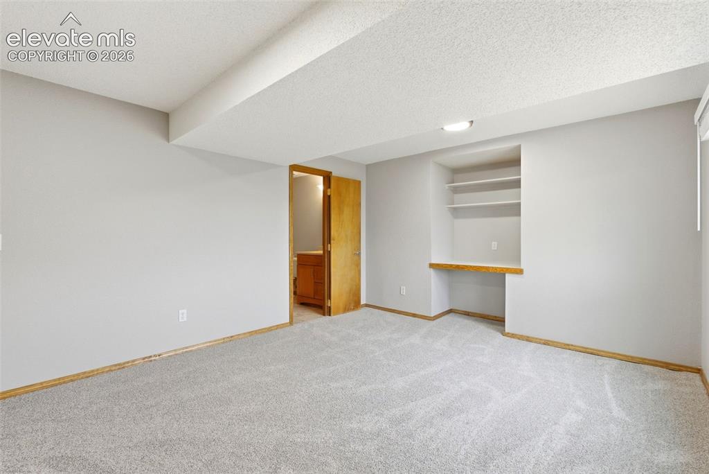 Image 46 of 50: 4th bedroom in basement with ensuite bath and built-in desk