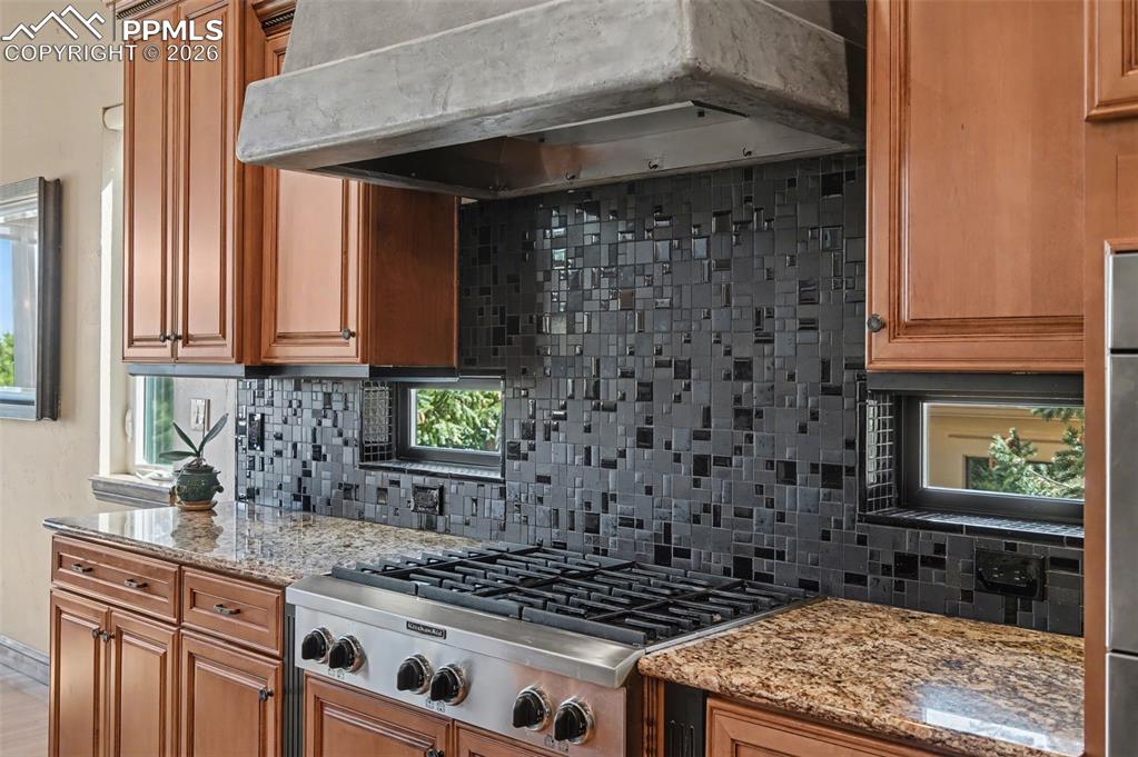 Image 12 of 42: Professional-grade appliances, striking stone countertops, and contrasting 