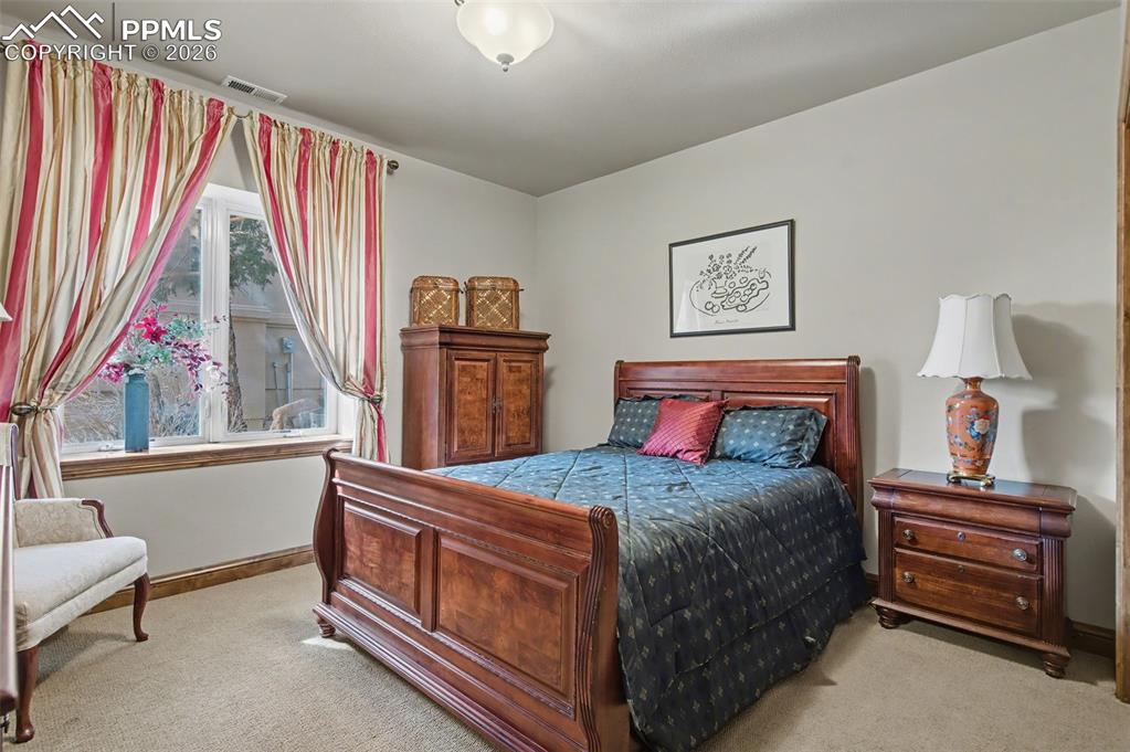 Image 30 of 42: A second private guest bedroom on the basement level offers ultimate comfor