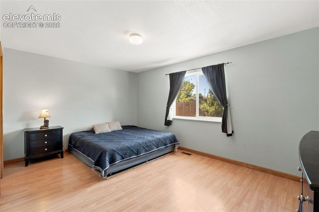 Image 12 of 34: Bright room featuring wood-finish flooring, light blue walls, and a recesse