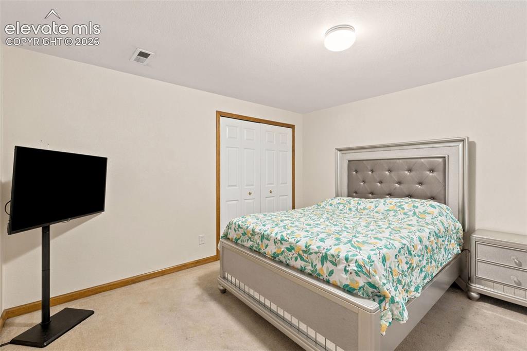 Image 20 of 34: Bedroom with neutral wall tones and light-toned carpet flooring